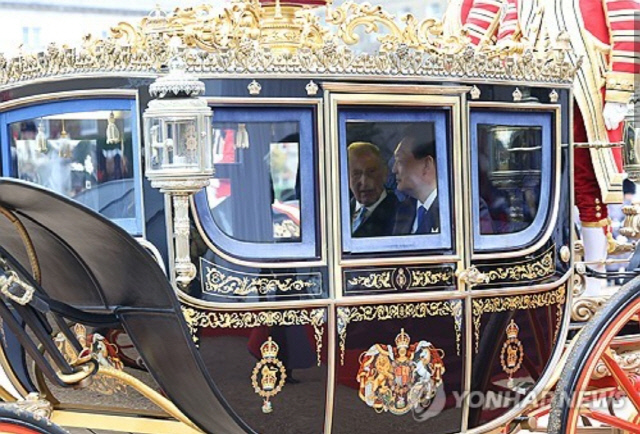 영국을 국빈 방문한 윤석열 대통령과 찰스 3세 영국 국왕이 21일(현지시간) 런던 호스가즈 광장에서 열린 공식환영식을 마친 뒤 마차를 타고 버킹엄궁으로 향하고 있다. 연합뉴스